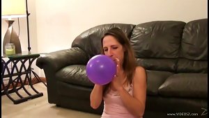Solo Model Teen In Miniskirt Blowing Balloons In A Cozy Room